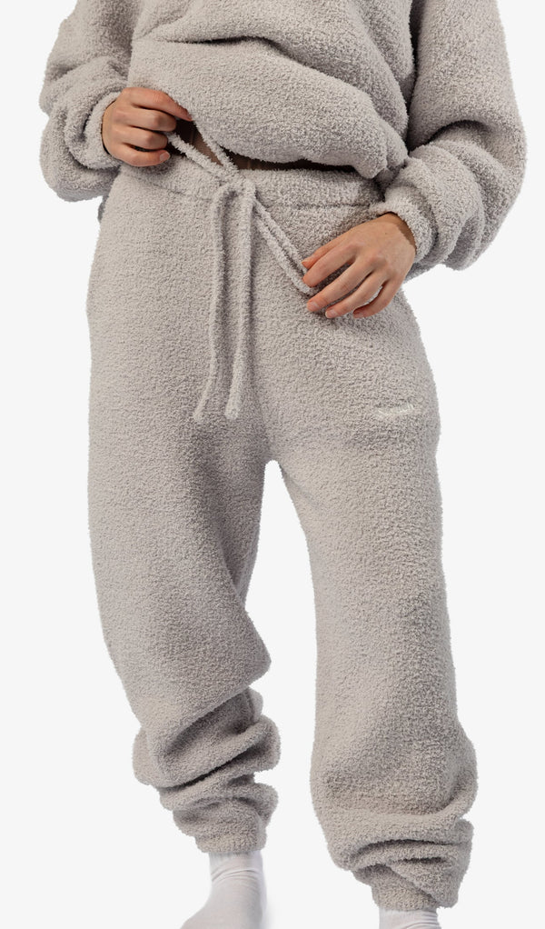 Person Wearing A Beige Fleece Tracksuit On A White Background 