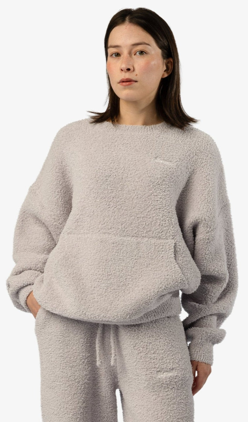Woman wearing a gray fleece outfit on a white background